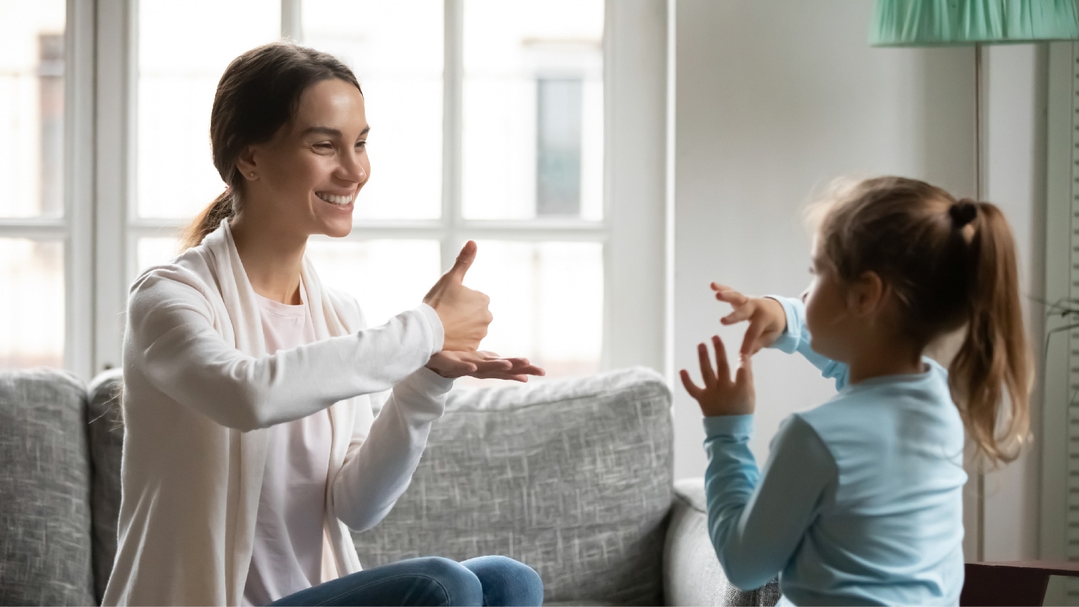 An adult and child learning ASL together