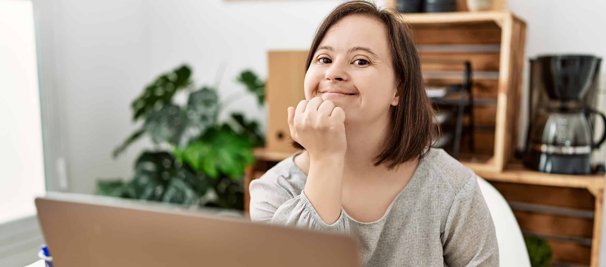 Brunette woman with down syndrome working at business office